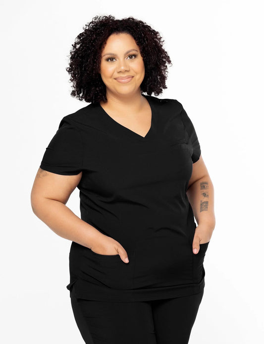 Smiling woman with curly hair wearing black medical scrubs with v-neck and pockets