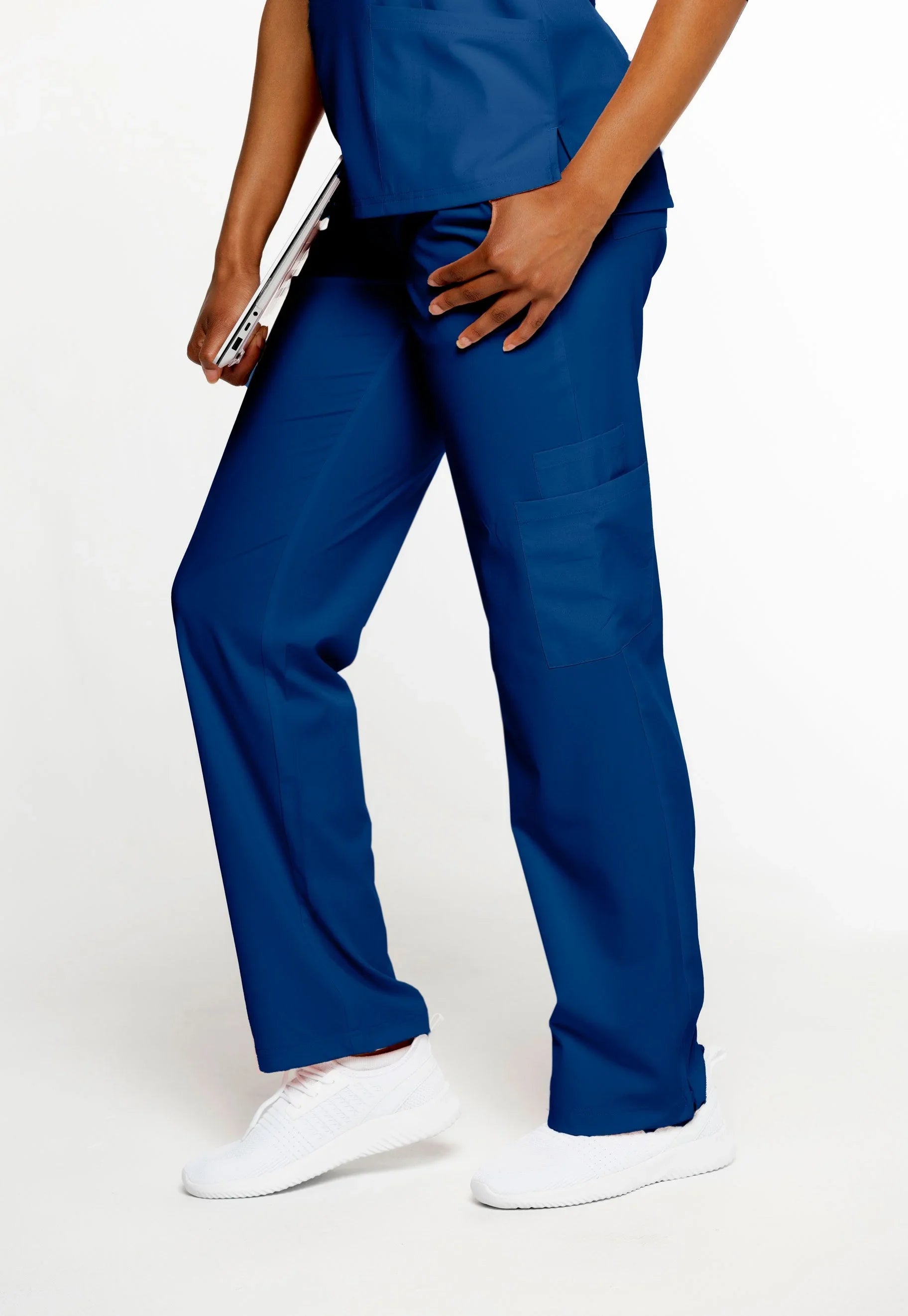 Person wearing navy blue medical scrub pants and white sneakers holding a tablet