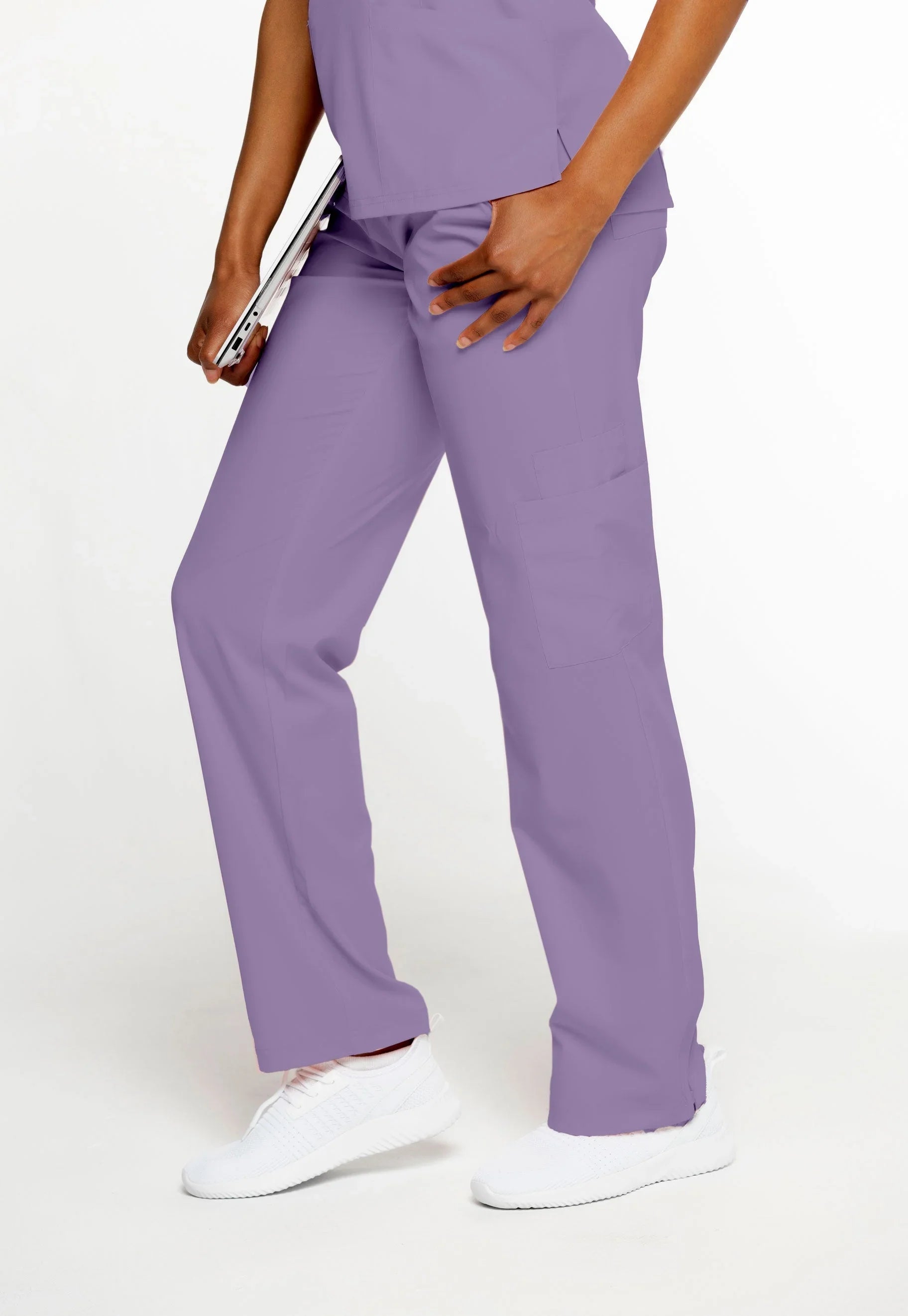 Person wearing lilac medical scrub pants and white athletic shoes holding a tablet