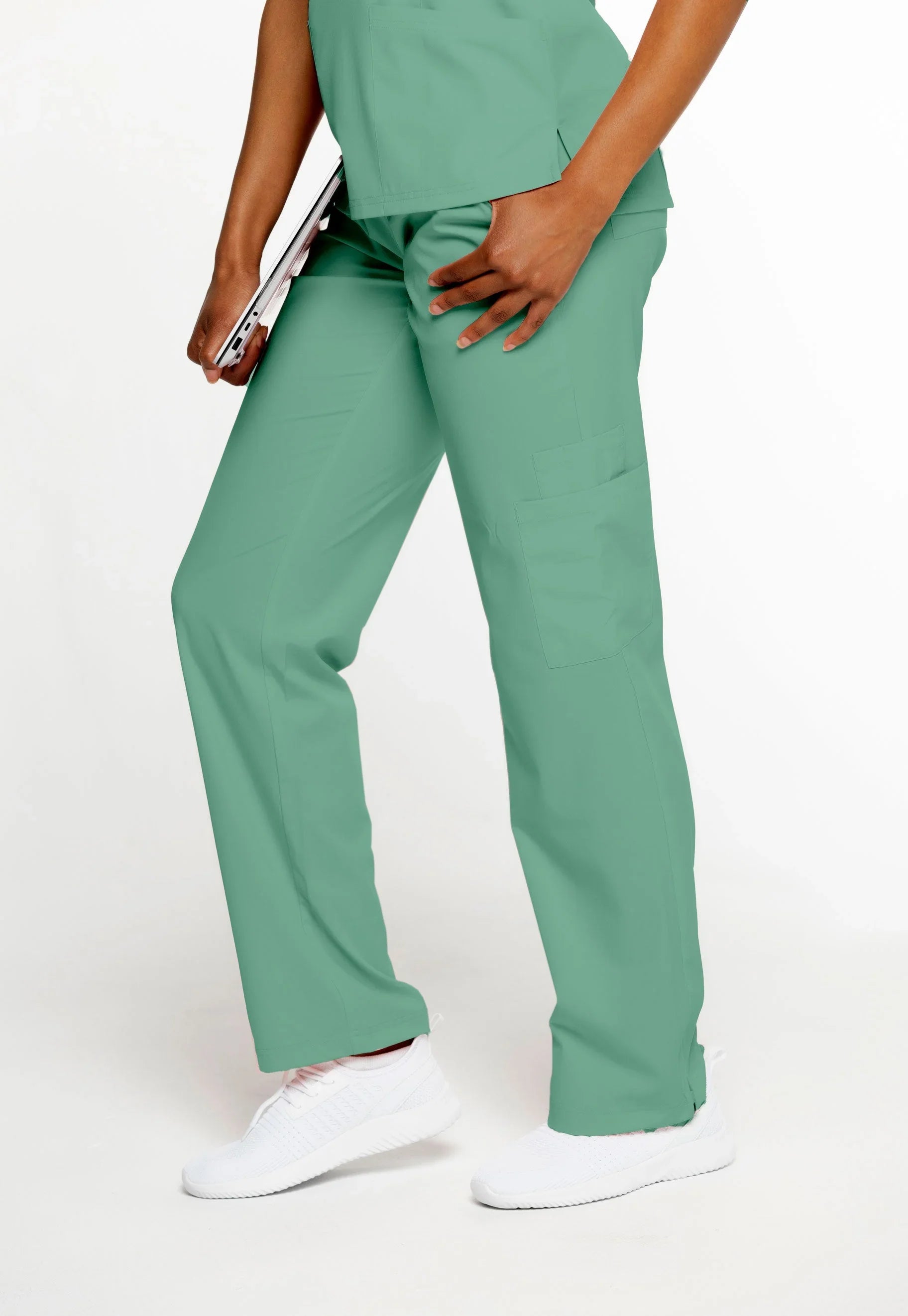 Medical scrub pants in sea green worn with white sneakers, featuring multiple pockets