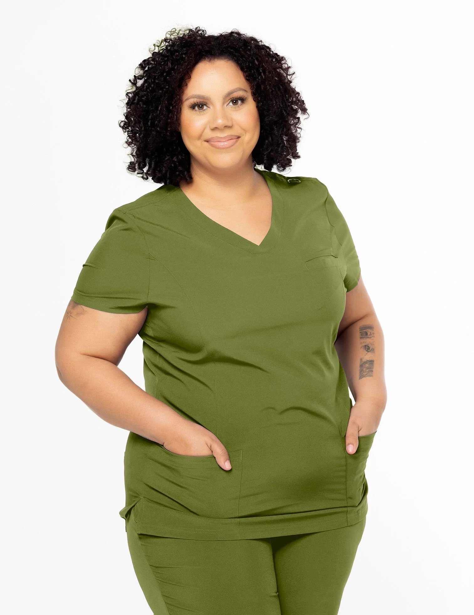 Plus size woman wearing olive green medical scrub top and pants with V-neck and pockets